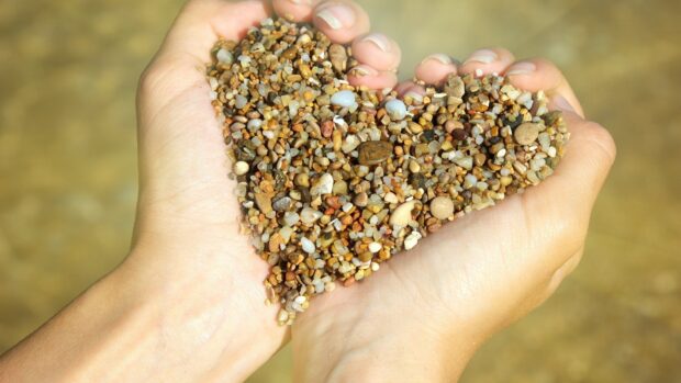 Hands holding a heart shape of small stones in natural light, 4K Desktop Wallpaper