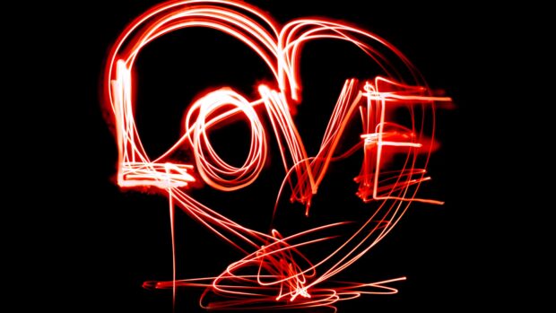 The image shows a heart shape with the word love written in red light trails, 4K Desktop Wallpaper