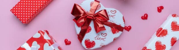 A heart shaped box with red ribbons and hearts design on a pink surface, 4K Desktop Wallpaper