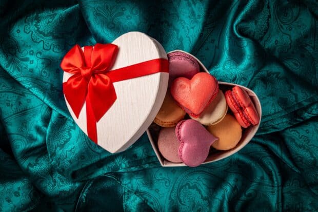 A heart shape gift box with colorful macarons on teal fabric, HD Desktop Wallpaper