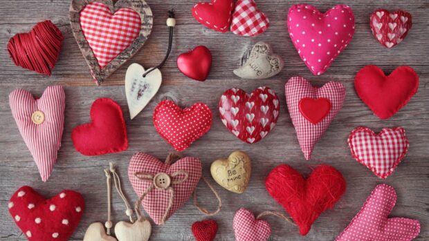 A collection of heart shapes in different designs and fabrics on a wooden surface, HD Desktop Wallpaper