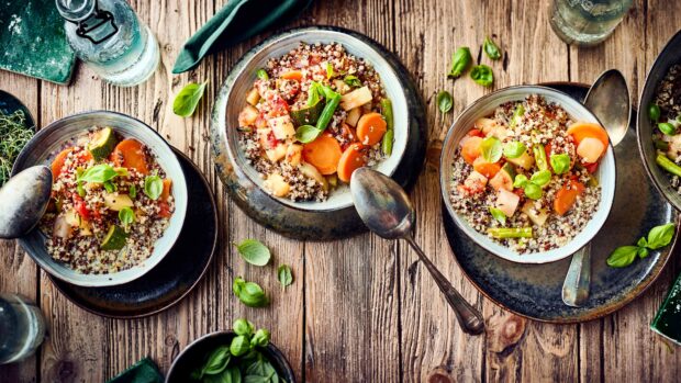 A top view of hearty quinoa bowls with fresh vegetables and herbs on a wooden table, 4K Desktop Wallpaper