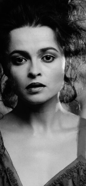 Helena Bonham Carter looks directly with intense expression in a black and white portrait, 2K Mobile Wallpaper