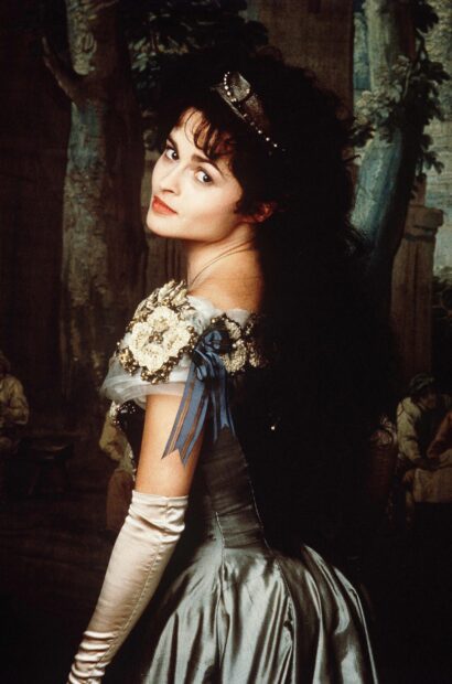 Helena Bonham Carter wears a vintage dress and gloves in a classic setting, 2K Mobile Wallpaper