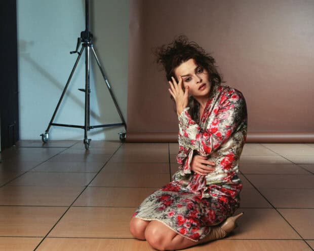 Helena Bonham Carter sits on the floor wearing a floral dress with a contemplative expression, HD Desktop Wallpaper