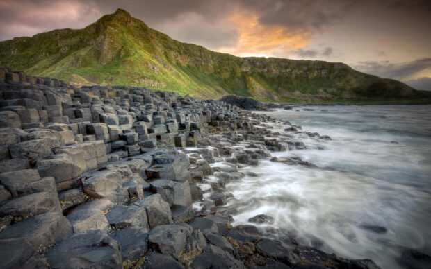 The Giants Causeway coastline features hexagonal basalt columns with waves crashing around them, 2K Desktop Wallpaper