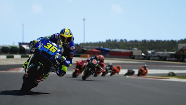 A rider in blue gear leads a motorcycle race on a professional track in racing game wallpapers, HD Desktop Wallpaper