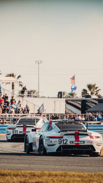 Two race cars competing on a race track with spectators watching, HD Mobile Wallpaper