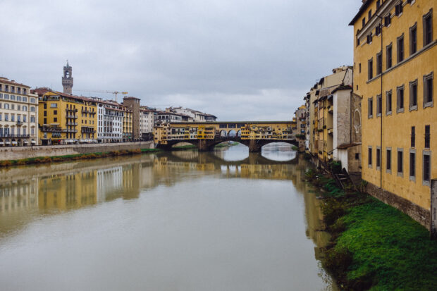 A stunning view of Ponte Vecchio shows old buildings lining the bridge and river, 2K Desktop Wallpaper