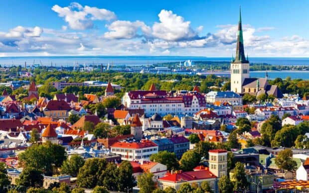 A panoramic view of historic Tallinn with colorful rooftops under a blue sky featuring Estonia Wallpapers, HD Desktop Wallpaper