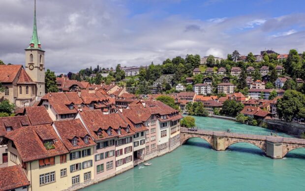 The River Aare in Switzerland flows beneath the old stone bridge and red roofed houses, HD Desktop Wallpaper