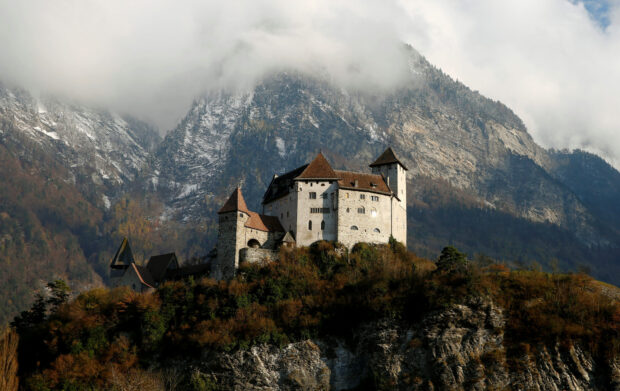 A historic castle sits among autumn trees with snowy mountains in the background in Liechtenstein Wallpapers, HD Desktop Wallpaper