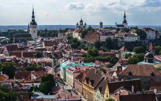A panoramic view shows historic buildings and churches in Estonia with a partly cloudy sky, HD Desktop Wallpaper
