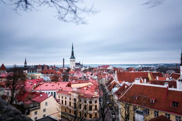 A panoramic view of Estonia rooftops with colorful buildings under a cloudy sky, HD Desktop Wallpaper