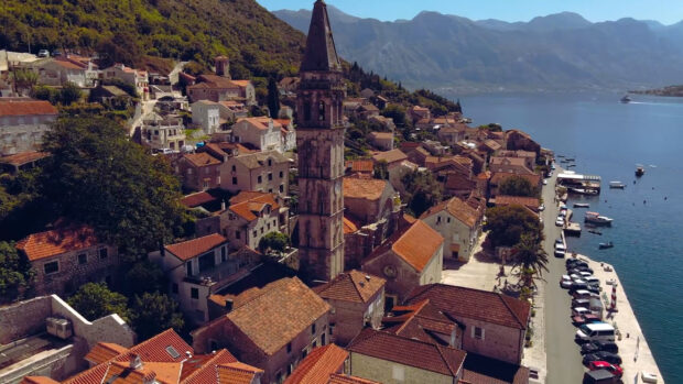 A beautiful view of a historic coastal town in Montenegro with old buildings and a calm sea, 2K Desktop Wallpaper