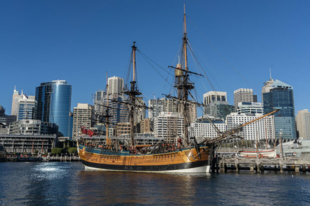 A historic wooden ship is docked in front of modern skyscrapers at the Maritime Museum, HD Desktop Wallpaper