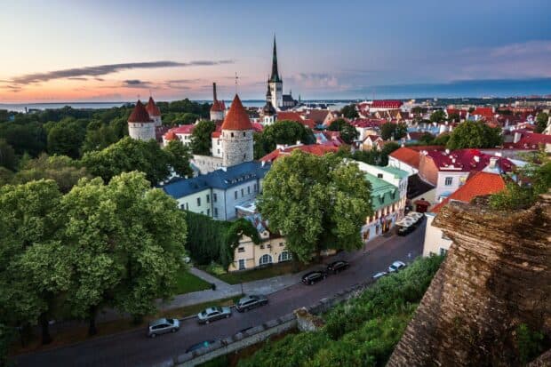 The Estonia cityscape features historic towers and spires under a sunset sky, HD Desktop Wallpaper