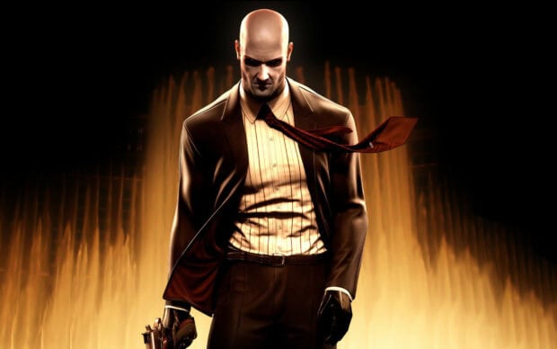 The Hitman Game character stands with a gun and flowing tie in front of flames, 2K Desktop Wallpaper