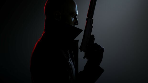 A man holding a silenced pistol with a raised collar in a dark setting shows Hitman Game, 4K Desktop Wallpaper