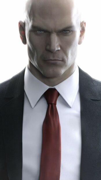 A serious Hitman character stares intensely with a dark suit and red tie in the Hitman Game Wallpapers 4K, HD Mobile Wallpaper