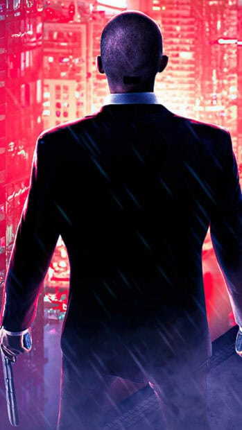 The Hitman character stands on a rooftop holding a gun with a neon city background in the rain, HD Phone Wallpaper