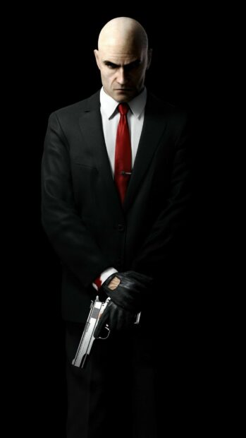 The Hitman stands in a black suit holding a gun with a serious expression, HD Mobile Wallpaper