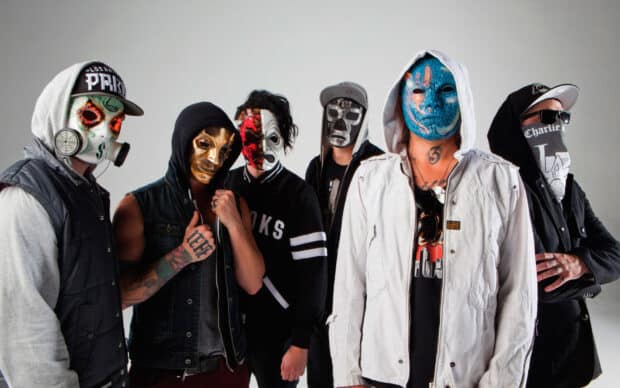 The Hollywood Undead band members are standing together wearing various artistic masks and hoodies, HD Desktop Wallpaper