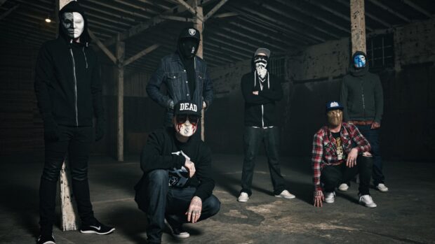 The Hollywood Undead band members wear masks and dark outfits in an industrial setting, HD Desktop Wallpaper
