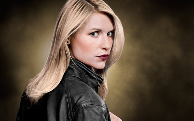 A focused blonde woman in a black leather jacket looks over her shoulder, 2K Desktop Wallpaper