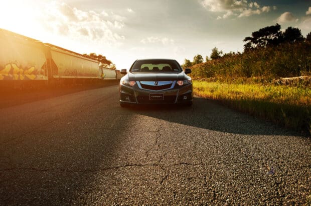 A Honda Accord is parked on an empty road near train cars during sunset, HD Desktop Wallpaper