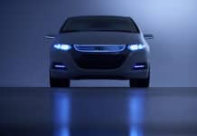 A Honda Insight is shown from the front with illuminated blue headlights and reflective surface, 2K Desktop Wallpaper