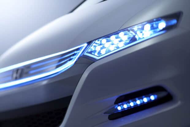The image shows a close up of the front lights and grille of a Honda Insight, 2K Desktop Wallpaper