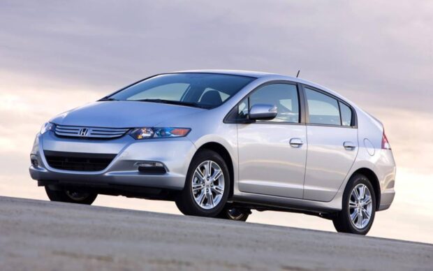 A silver Honda Insight car is parked on a hill with a cloudy sky in the background, 2K Desktop Wallpaper