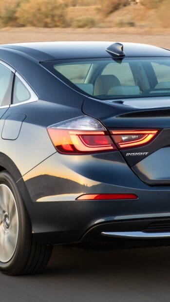 The Honda Insight displays its rear light and aerodynamic design on a smooth road, 2K Mobile Wallpaper