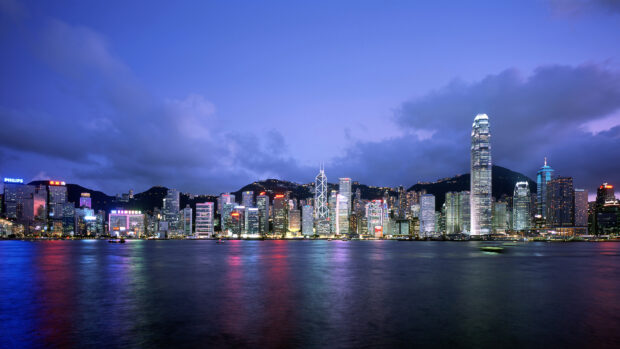 The Hong Kong skyline features illuminated skyscrapers reflecting on the water at dusk, HD Desktop Wallpaper