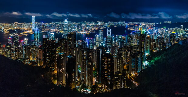 A spectacular view of the Hong Kong skyline illuminated at night with tall buildings, 2K Desktop Wallpaper