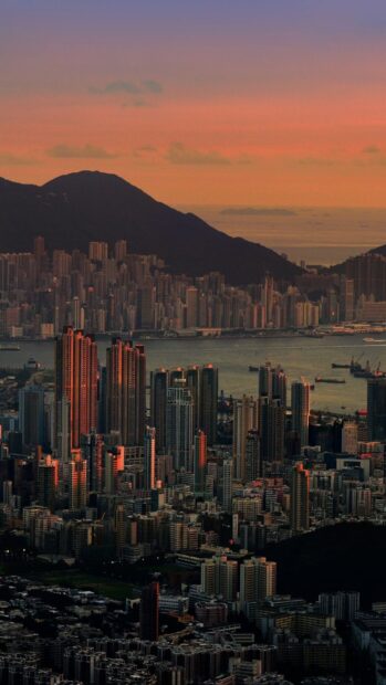 The Hong Kong skyline glows under the colorful sunset sky with mountains and sea in the background, HD Mobile Wallpaper
