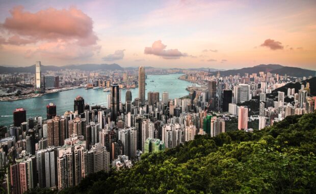 A beautiful view of Hong Kong skyline with tall buildings and mountains under a colorful sky, 2K Desktop Wallpaper
