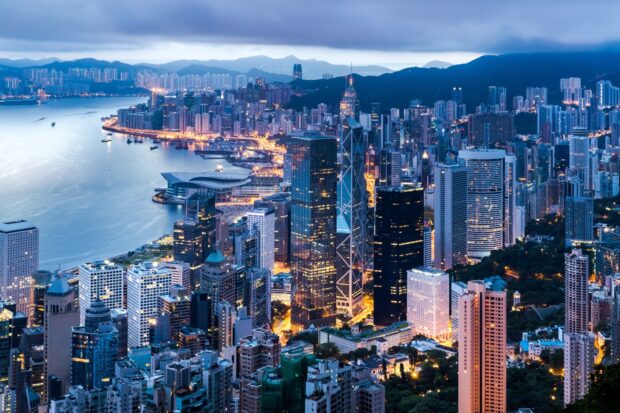 The Hong Kong skyline is illuminated with city lights and coastal hills in the background, HD Desktop Wallpaper