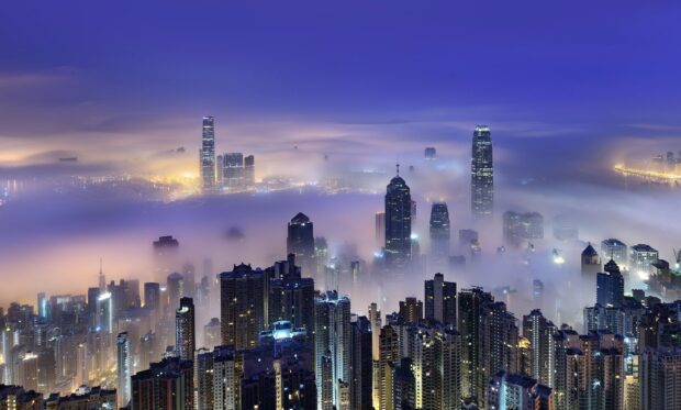 The Hong Kong skyline is covered in fog with illuminated skyscrapers shining, HD Desktop Wallpaper