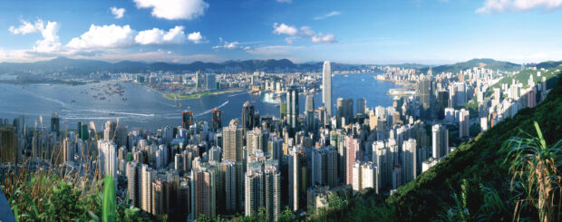 The Hong Kong skyline features tall buildings and a busy harbor under a blue sky, 2K Desktop Wallpaper