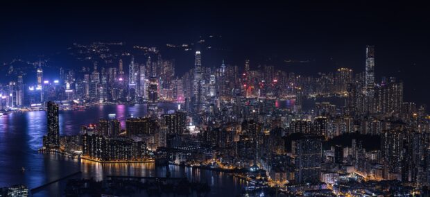 The Hong Kong skyline shows a vibrant city illuminated under the night sky with its iconic buildings, HD Desktop Wallpaper