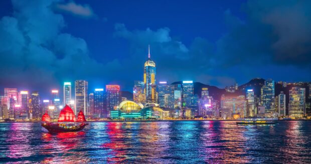 The Hong Kong skyline features illuminated skyscrapers and vibrant harbor reflections, 2K Desktop Wallpaper