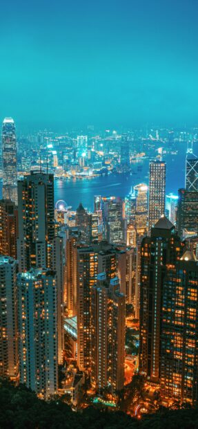 The Hong Kong skyline shows illuminated skyscrapers and waterfront at night, 2K Mobile Wallpaper