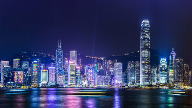 The Hong Kong skyline shows illuminated skyscrapers reflecting over the water at night, HD Desktop Wallpaper
