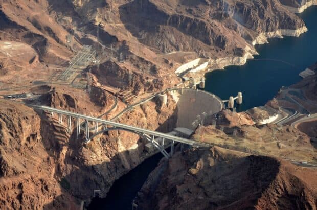 The aerial view shows Hoover Dam surrounded by rocky terrain and the flowing Colorado River, HD Desktop Wallpaper