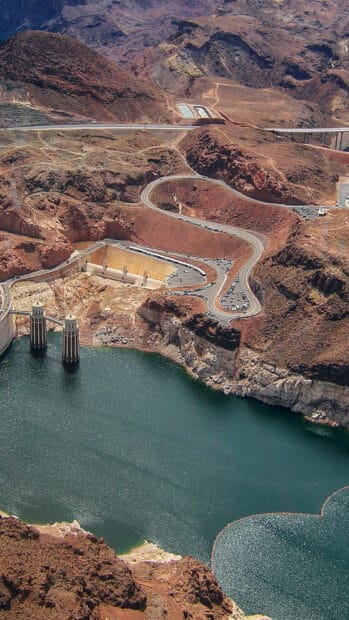 This image shows Hoover Dam with its curved roads and reservoir in a desert area, HD Mobile Wallpaper