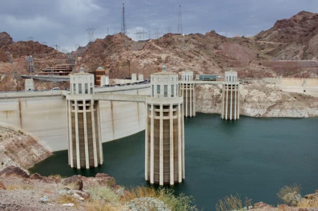 The Hoover Dam stands tall with surrounding rocky terrain and water in the reservoir, HD Desktop Wallpaper