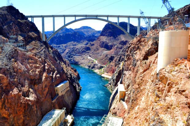 The Hoover Dam shows a stunning river running through rocky cliffs under a large bridge, 2K Desktop Wallpaper