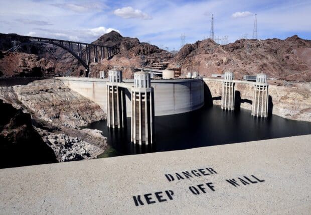 The Hoover Dam stands tall between rocky landscapes under a cloudy sky, HD Desktop Wallpaper